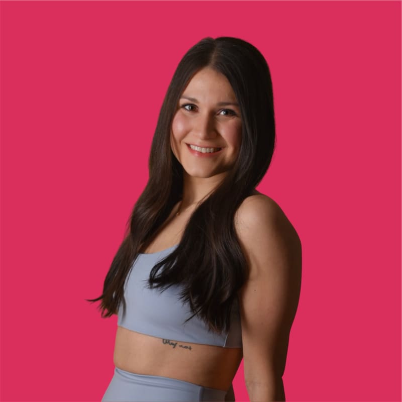 Aylin lächelt in die Kamera vor pinkem Hintergrund